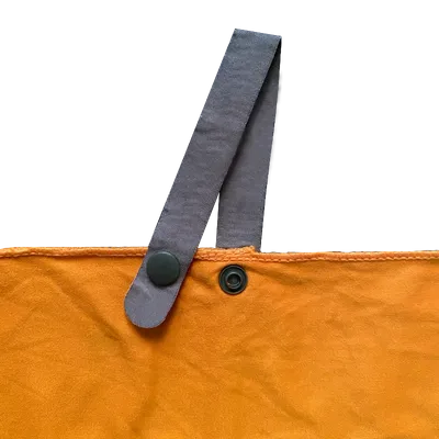 A close-up of a mustard-colored towel's edge with a grey hanging loop and snap fasteners, indicating a focus on premium towels online.